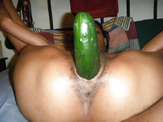 Her black pussy is filled with a huge cucumber